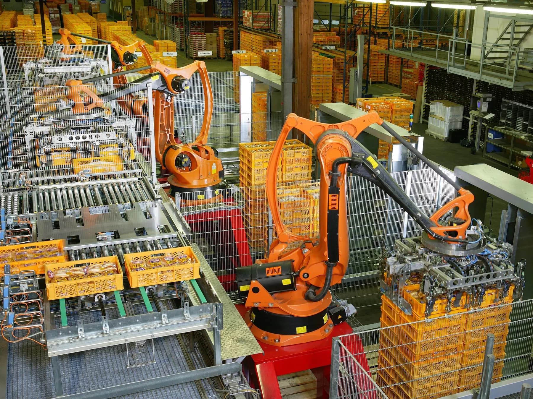 Roboti industriali care paletizeaza produse intr-o fabrica